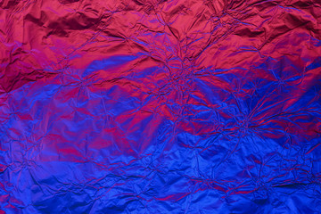 Blue red deformed background made of neon lights foil. Trendy duotone texture