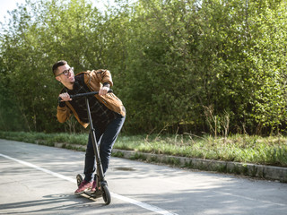 yong man on the kickscooter with smartphone