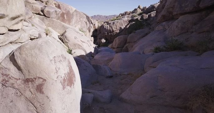 Low angle aerial shot of historic geoglyphs and pictographs on rocks and boulders at well known Coyote Hole in Joshua Tree National Park, California.