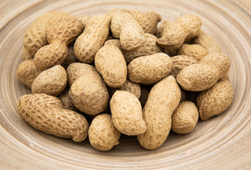 Peanuts in shells in a clay plate