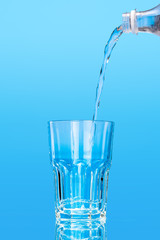 Close up pouring purified fresh drink water from the bottle on table