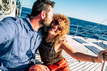 Happy tourist couple of traveler people in love enjoying the sail boat trip together having fun and...