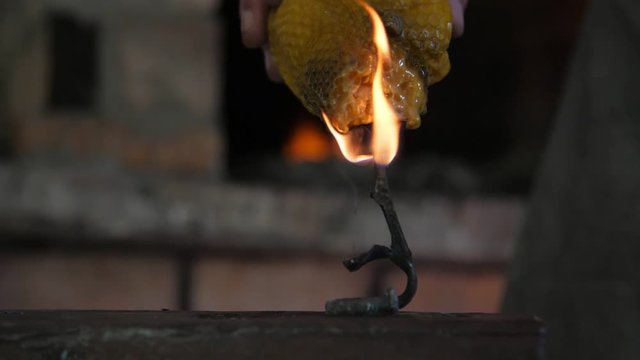 Spellful iron rose in fire put on an anvil in a dim blacksmith workshop  