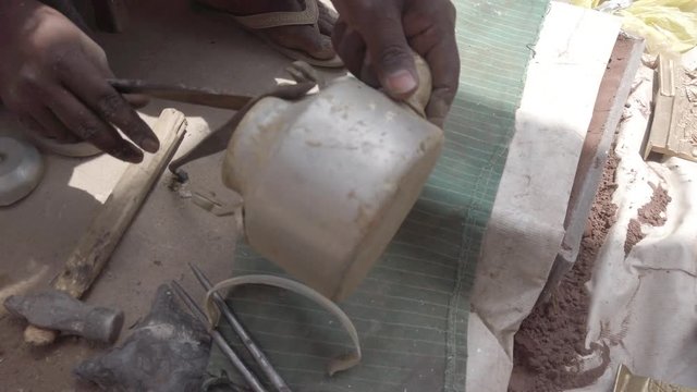 Metal workers at roadside India cutting daily metal objects and then metaling them in a DIY makeshift burning chamber in earth to make objects -4k stabilized gimbal slow-motion close-up