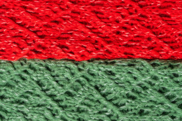 Red and green knitted woolen sweater texture. Colorful textured background. Laid horizontal.