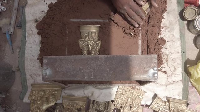 Indian metal workers casting Hindu God and Goddess idols using recycled up-cycled melted metal from everyday objects at a makeshift roadside workshop in India- 4k slow-motion handheld stabilized 