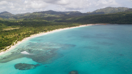 White sandy beach on a tropical island and clear sea. Top View of paradise tropical beach in sunny day. Beautiful sea view, shot by drones. Coral reef Aerial view. Uninhabited island