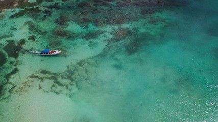 Fototapeta na wymiar Boat on the sea. Beautiful bay with turquoise water. View from above. Tourist boat on the sea near a coral reef. Yacht in the sea bay. Aerial view. . 