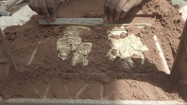 Indian metal workers casting Hindu God and Goddess idols using recycled up-cycled melted metal from everyday objects at a makeshift roadside workshop in India- 4k slow-motion handheld stabilized 