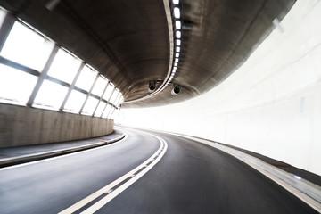 Blurry concrete tunnel with empty road.