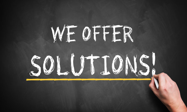 We Offer Solutions concept from analyst, consultancy or advisor with a businessman writing the words in chalk on a blackboard conceptual of problem solving