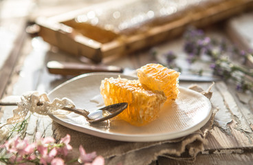 Honey comb  from honey dipper in wooden bowl. Close-up. Healthy organic Thick honey dipping from the wooden honey spoon, closeup.