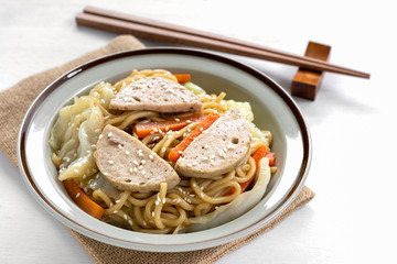 close up of stir fried japanese noodles with vietnamese pork sausage in a ceramic dish. asian...