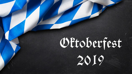 Tischtuch mit bayrischem Rautenmuster und Kreidetafel mit Aufschrift "Oktoberfest 2019" 