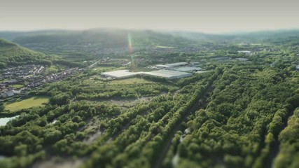 high speed drone reverse hyperlapse through the rolling hills of the Welsh Cynon Valley from Cwmbach to Ysbyty Cwm Rhondda, Mountain Ash during a bright sunny afternoon.