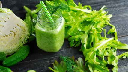 Green smoothie with cucumber, cabbage and healthy greens on the table