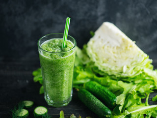 Green smoothie with cucumber, cabbage and healthy greens on the table