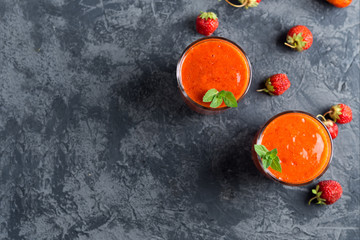 Strawberry red natural homemade smoothie in two glasses on the table copy space