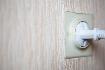 Electric plug in the old white socket