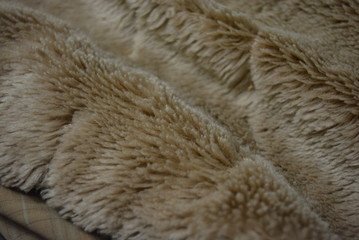 Soft coffee synthetic fabric in the form of natural long fur. Brown synthetic fur in spacing arrangement with different structure and shape.