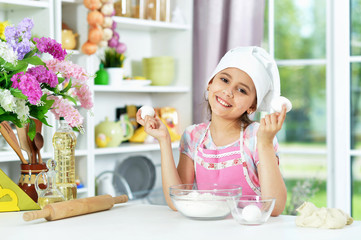 Cute girl making dough in the kitchen