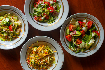 Several salads with vegetables and greens. Healthy food concept. Mixed vegetables