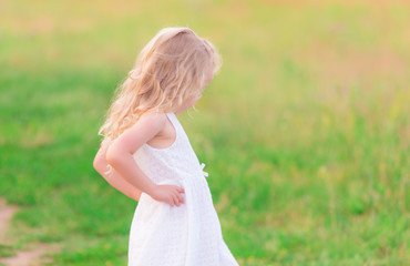 Fototapeta na wymiar Beautiful blond little girl in the field