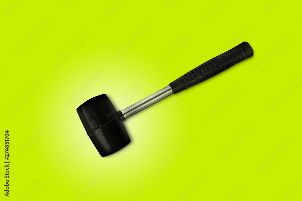 Wall mural Close up black rubber mallet isolated on bright green background. Rubber hammer is a construction tool. Clipping path.