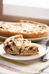 Slice of chicken tart with mushrooms and cheese on a plate