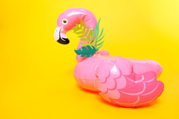 Inflatable pink flamingos on a bright yellow background.