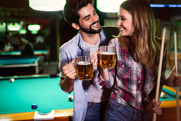 Couple drinking beer and playing snooker on date