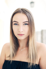 Portrait of young beautiful woman looking at camera over street blurred background.