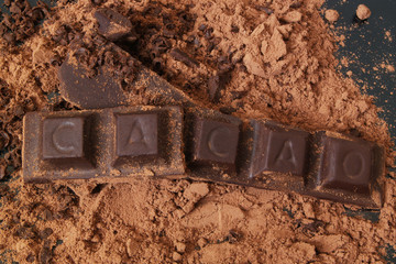 Chocolate bars with word CACAO on  cocoa powder