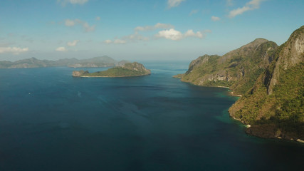 Seascape with tropical bay, rocky islands, ocean blue water, aerial view. islands and mountains covered with tropical forest. El nido, Philippines, Palawan. Tropical Mountain Range