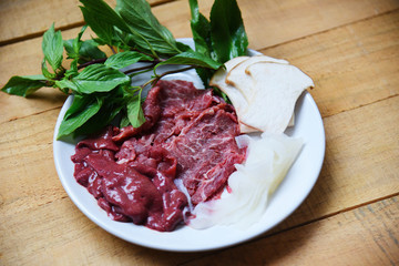 Set of meat beef slice liver and mushroom vegetables on white plate for cooked or Sukiyaki Shabu shabu Japanese foods