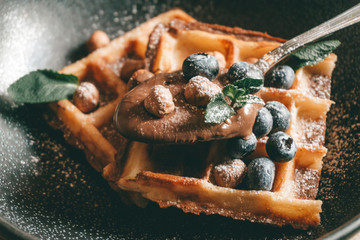 Belgian waffles with berries, ice cream and chocolate. Breakfast table setting. Morning lifestyle concept. - Powered by Adobe
