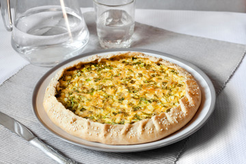 Tart with eggs and green onions on a plate