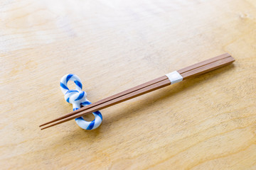 Chopsticks placed on chopstick rest on the wooden table