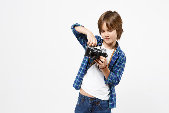 Fun little kid boy in blue t-shirt hold retro vintage photo camera, doing photo shot isolated on white wall background children studio portrait. People childhood lifestyle concept. Mock up copy space.