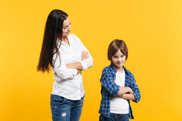 Happy woman in casual clothes have fun with child boy. Mother, little kid son holding hands crossed isolated on yellow orange wall background. Mother's Day, love family, parenthood childhood concept.
