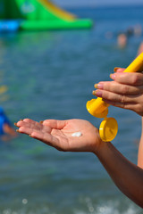 Girl squeezes sunscreen into her palm