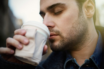 Close up portrait of young man drinking morning coffee
