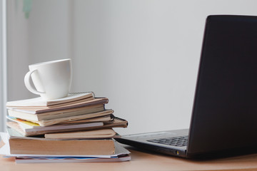 Cup of coffee with stack document and laptop on office desk.Copy space.