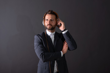 Naklejka premium A serious young businessman listening to music