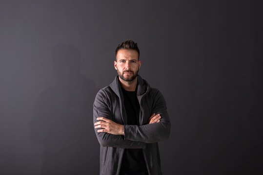 A serious young man standing in a studio