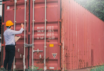 Male engineer inspection checking on container background With note on notepad or...