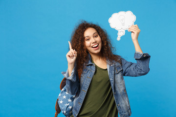 Young african american girl teen student in denim clothes, backpack hold clock isolated on blue wall background studio portrait. Education in high school university college concept. Mock up copy space © ViDi Studio