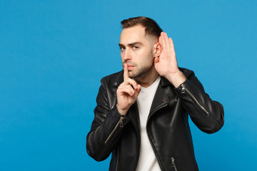 Stylish bearded man in black leather jacket white t-shirt say hush be quiet with finger on lips...