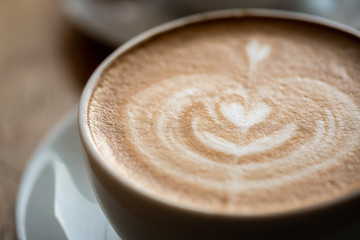 A cup of coffee on desk, Cup of coffee in hand, mug of latte coffee, Close up concept.