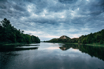 Fototapeta premium cloudy sky on the river in the summer evening